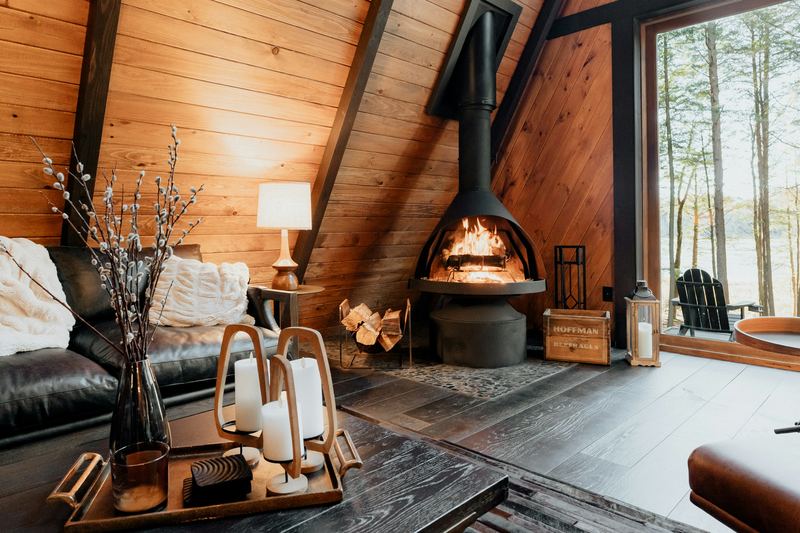 Cozy living room with a wood-paneled A-frame ceiling and a hanging fireplace